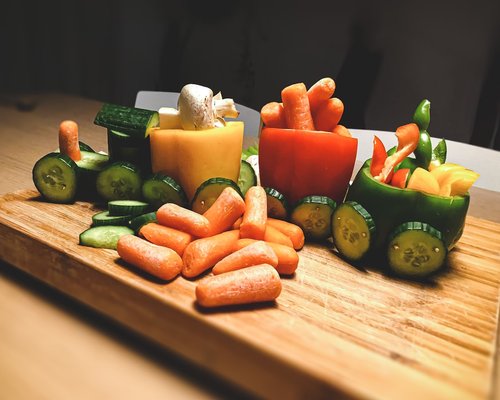Fresh carrots and green vegetables on a wooden table