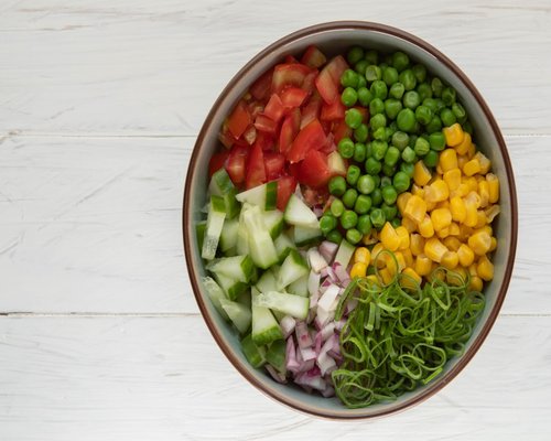 Top view of healthy colorful salad bowl preparation